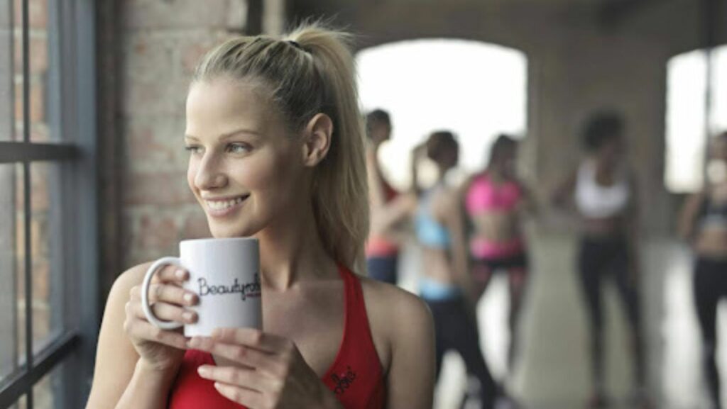 woman drinking coffee in a workout studio